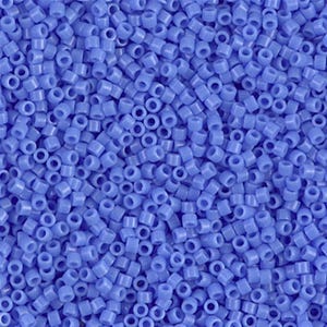 Peut inclure: Gros plan sur une grande quantité de petites perles de rocaille opaques bleu clair. Les perles sont rondes et ont un trou au centre.