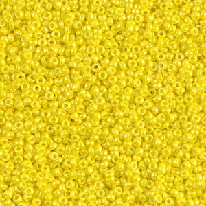 May include: A close-up view of a large quantity of small, round, yellow seed beads. The beads have a slight sheen and are perfect for crafting.