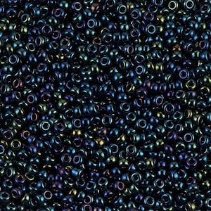 May include: A close-up view of a large quantity of small, round, dark blue seed beads with iridescent shimmer.