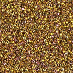 May include: A close-up view of a large quantity of small, gold-colored seed beads. The beads have a metallic sheen and are arranged in a random pattern.