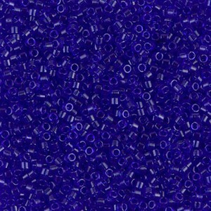 May include: A close-up view of a large quantity of small, round, opaque, dark blue glass seed beads.