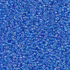 May include: A close-up view of a large quantity of small, round, iridescent blue seed beads.