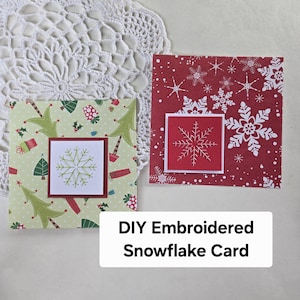 May include: Two square greeting cards featuring embroidered snowflake designs. One card has a light green background with Christmas trees and gifts, while the other has a red background with white snowflakes. Text reads DIY Embroidered Snowflake Card.
