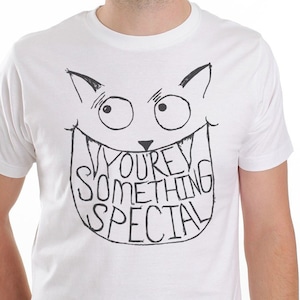 May include: White t-shirt with a black and white illustration of a cat with a big smile and the text "You're Something Special" inside the mouth.