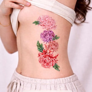 May include: A large temporary tattoo featuring a floral design of pink, purple, and red chrysanthemums with green leaves. The tattoo measures 4 inches by 10 inches.