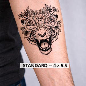 Può includere: Tatuaggio temporaneo in bianco e nero di una testa di tigre con una corona floreale. La tigre ruggisce, con i denti scoperti. Il testo "STANDARD - 4 x 5.5" è stampato sotto. Misura circa 10,16 cm x 13,97 cm.