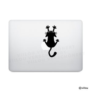 May include: Black cat silhouette sticker with a playful design, hanging upside down with its paws in the air. The sticker is placed on a silver laptop.