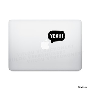 Könnte beinhalten: Ein weißes Laptop mit einem schwarzen Sprechblasen-Aufkleber mit der Aufschrift "YEAH!". Der Aufkleber befindet sich in der Nähe des Apple-Logos. Der Aufkleber ist ein lustiges und einfaches Design.