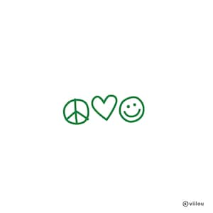 Op de afbeelding: Een witte achtergrond met drie groene doodles: een vredesteken, een hart en een smiley. De afbeelding brengt een boodschap van vrede, liefde en geluk over. De naam van de kunstenaar, viilou, staat rechtsonder.
