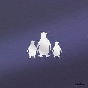 Op de afbeelding: Silhouet van drie pinguïns op een paarse achtergrond. De pinguïns zijn wit en kijken naar de rechterkant van de afbeelding. De grootste pinguïn bevindt zich in het midden, met een kleinere pinguïn aan elke kant.