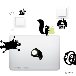 Pu&ograve; includere: Un set di adesivi in vinile nero per pareti e laptop raffiguranti una lumaca con una barchetta di carta, uno scoiattolo con una mela verde chiaro, un pipistrello appeso, uno scoiattolo volante e un camaleonte. Testo example - sticker visibile.
