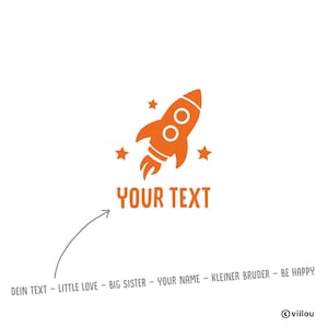 Könnte beinhalten: Orangefarbene Raketen-Grafik mit drei Sternen und dem Text "YOUR TEXT" auf weißem Hintergrund. Darunter ein Pfeil, der auf eine Liste von Sätzen zeigt, darunter "DEIN TEXT - LITTLE LOVE - BIG SISTER - YOUR NAME - KLEINER BRUDER - BE HAPPY".