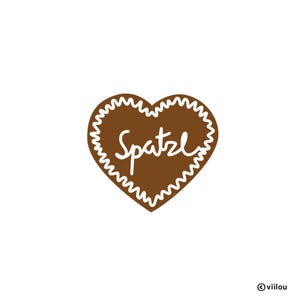 Könnte beinhalten: Ein brauner herzförmiger Lebkuchen mit weißem Zuckerguss und dem Wort "Spatzle" darauf.
