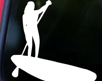May include: White silhouette of a person stand-up paddleboarding. The person is facing away from the viewer and holding a paddle in their right hand. The paddleboard is long and narrow.