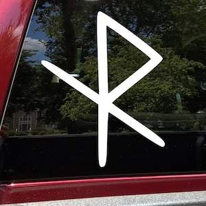 May include: White vinyl decal of the Vegvisir symbol, a Norse directional symbol, on a red car window.