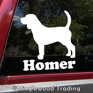 May include: White vinyl decal of a Bloodhound dog silhouette with the name "Homer" underneath. The decal is on a black car window.