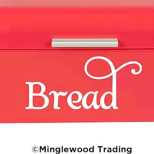 May include: A bright pink metal bread box with a white inscription that says "Bread" and a silver handle.