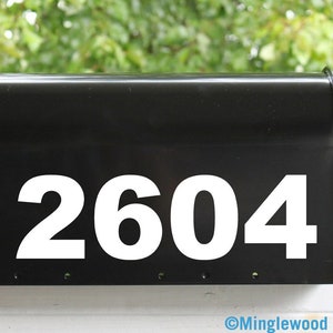 May include: A black mailbox with a red flag and white numbers "2604" on the front.