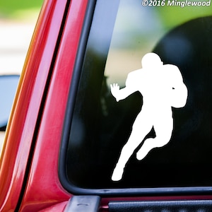 May include: White silhouette of a football player running with the ball. The silhouette is on a black background.