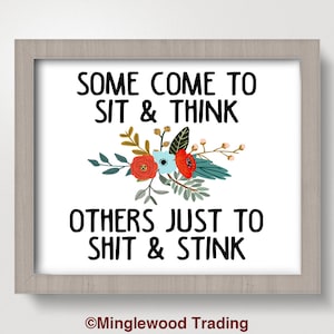 May include: A white framed print with a floral design and the text "Some come to sit & think others just to shit & stink" with the copyright information "©Minglewood Trading" at the bottom.