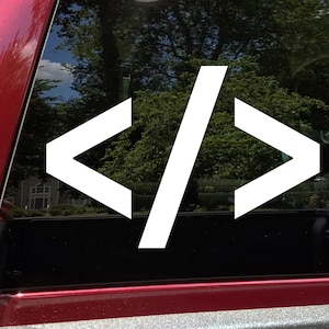 May include: White vinyl decal of the code symbols "< / >" on a black car window.