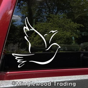 May include: White vinyl decal of a stylized dove in flight, applied to a red car window. The decal is a simple outline of the bird with a wingspan of approximately 10 inches.
