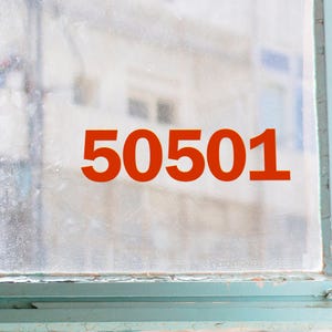 May include: A window with the number "50501" in a bold, orange font. The number is centered on the window, which has a slightly blurred background. The window frame is a faded teal color.