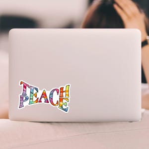 A laptop personalized with a Teach Peace sticker, enhancing the device with a splash of color and a meaningful message.