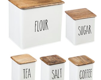 May include: Set of six white metal canisters with wooden lids. The canisters are labeled "Flour", "Sugar", "Tea", "Salt", "Coffee".