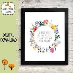 May include: A framed print with a floral wreath surrounding the text "IN THIS HOUSE WE SAY PLEASE, THANK YOU AND FUCK TRUMP." The print is a digital download and features a black frame.