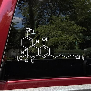 May include: A white vinyl decal applied to a vehicle window, displaying the complex chemical structure of THC. The graphic features white lines representing molecular bonds, along with chemical labels including CH3, H, and OH in a clear font.