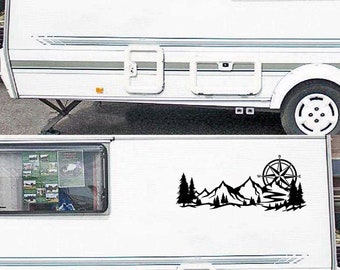 Puede incluir: Calcomanía en blanco y negro de una brújula, montañas y árboles. La calcomanía se aplica al costado de una autocaravana blanca.