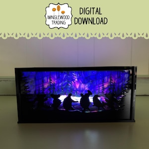 May include: A black rectangular light box with a winter forest scene. The scene features silhouettes of animals and trees against a backdrop of purple, blue, and white lights. The text "DIGITAL DOWNLOAD" is visible.
