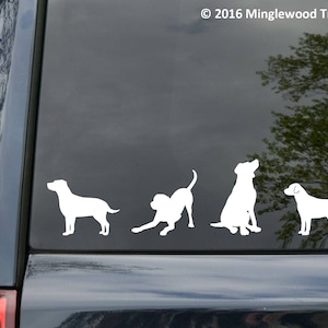 May include: White vinyl decal of four dogs in different poses. The dogs are all facing the right side of the image. The decal is on a black car window.