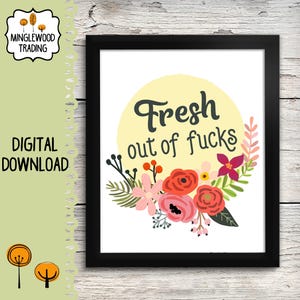 May include: A framed art print with the text "Fresh out of fucks" in a whimsical font, surrounded by a floral arrangement of pink, red, and purple flowers. The print is set against a white background with a yellow circle behind the text.