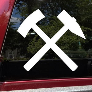 May include: White vinyl sticker of two crossed hammers, a common symbol for mining and labor.