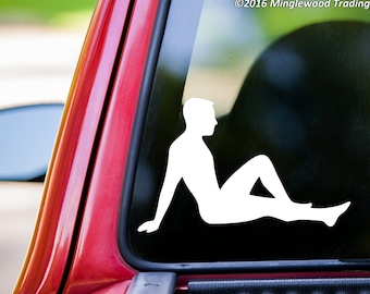 May include: White vinyl decal of a person sitting with legs outstretched. The decal is on a red car window.