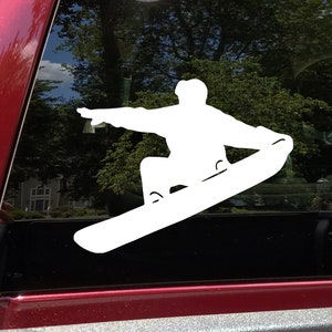 May include: White silhouette of a person snowboarding on a car window.