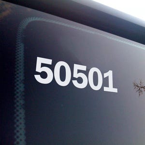 May include: White numbers "50501" are displayed prominently on a dark surface, possibly a window or screen. The numbers are large and easy to read, with a clean, modern font. The background is a gradient of dark colors.