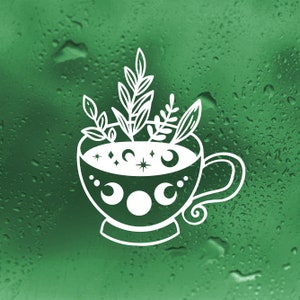 May include: A white outline illustration of a teacup with a moon and stars design. The teacup is filled with herbs and has a swirling handle. The image is on a green background with water droplets.