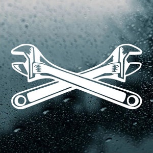 May include: White vinyl decal of two crossed wrenches. The wrenches are in a simple, stylized design.