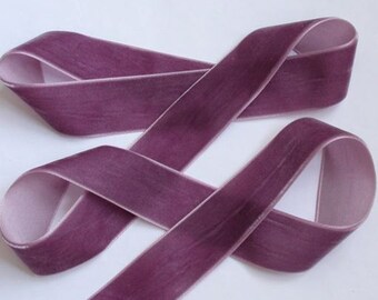 Puede incluir: Primer plano de una cinta de terciopelo color ciruela, en bucles y dispuesta sobre una superficie blanca. La cinta tiene un aspecto suave y texturizado con un borde más claro, rosado. Adecuada para manualidades o decoración.