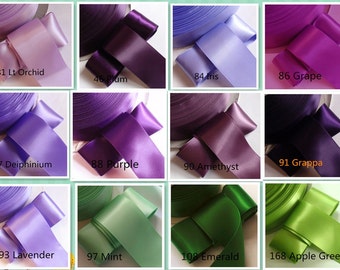 May include: A collection of satin ribbons in various colors, including shades of purple, green, and lavender. Each ribbon is labeled with a color name and number, such as "81 Lt Orchid" and "108 Emerald".