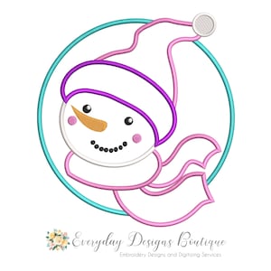 May include: A whimsical snowman design with a white hat, orange nose, and black eyes and mouth, framed by a teal circle. The snowman has a pink scarf and is surrounded by a pink and purple outline. The text "Everyday Designs Boutique" is at the bottom.