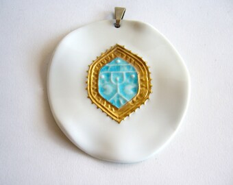 May include: A white ceramic pendant with a gold-rimmed turquoise blue geometric design in the center.