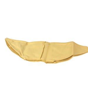 Peut inclure: Un vêtement en tissu jaune pâle présentant une silhouette large et incurvée avec une couture verticale centrale. L'article est fabriqué dans une matière tissée douce avec des coutures visibles sur les bords et une teinte jaune doré uniforme.