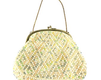 Puede incluir: Un bolso de mano vintage con cuentas y un asa de cadena dorada. El bolso presenta un exterior de cuentas de color crema con un patrón de cuentas de colores pastel. El marco es de metal dorado con cierre de broche.