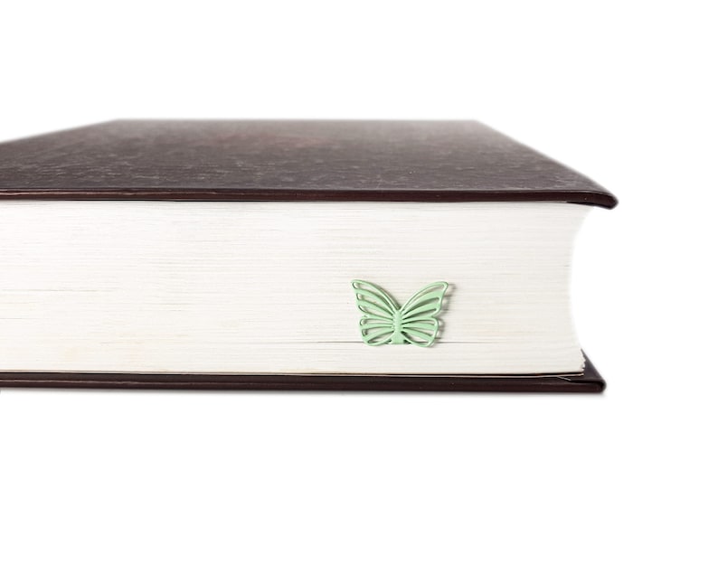 Mint metal bookmark Butterfly. A flat metal stick stays between the pages of the book. The butterfly is on the side of the book. It is visible even when the book is closed. Made in our workshop in Ukraine. Not mass manufactured.