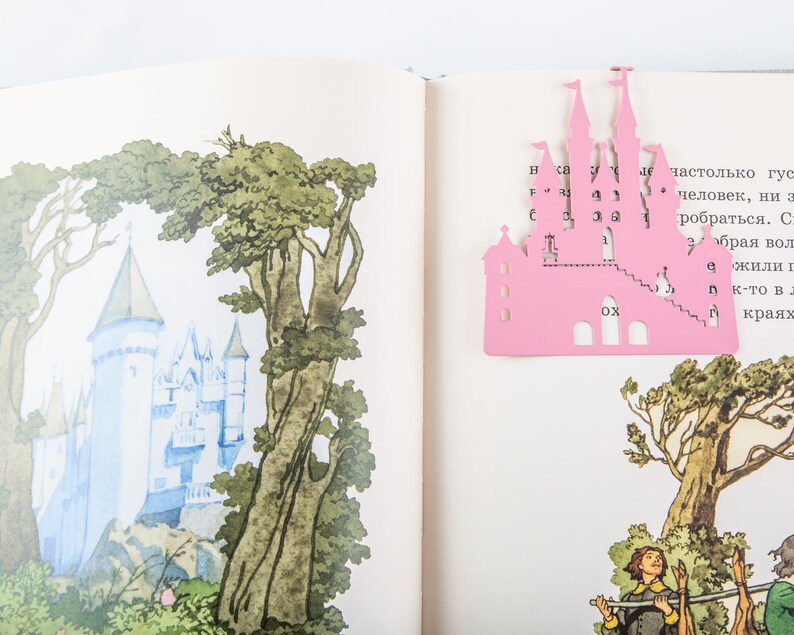 Pink metal bookmark Princess Castle. The large pink castle is between the pages of the book. The little crown is on the side of the book. It is visible even when the book is closed. Made in Ukraine. Not mass manufactured.
