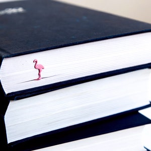 Pink metal bookmark Flamingo. A long, flat metal stick stays between the pages of the book - Cool Bookmark
